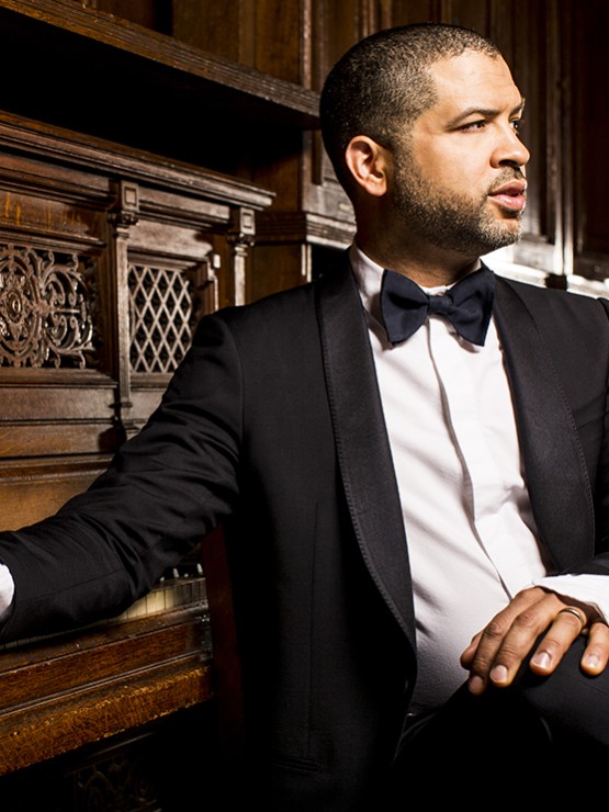 Jason Moran, a black man in a tuxedo sitting in front of a piano.