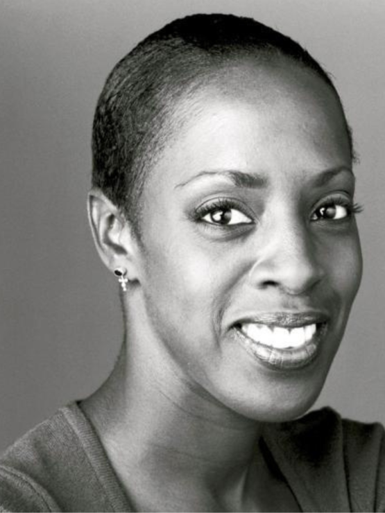 a black and white, portrait of a smiling black woman, turned most of the way toward the camera