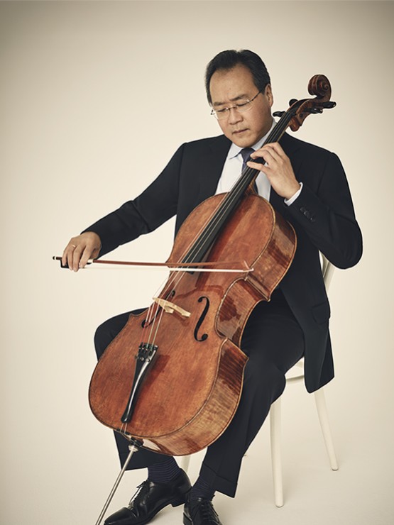yo-yo ma plays his cello against a light ivory background with vignette effect