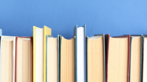 pages of clothbound books, side by side, in front of a blue background