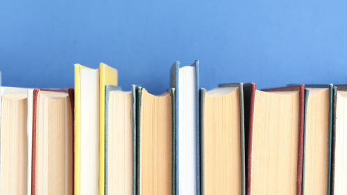 a row of clothbound books in front of a blue background