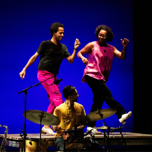 two men stand on a platform, tap dancing kicking one leg out