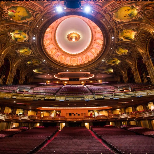 A view from the stage, out into a large auditorium with ornate gold decorations and paintings