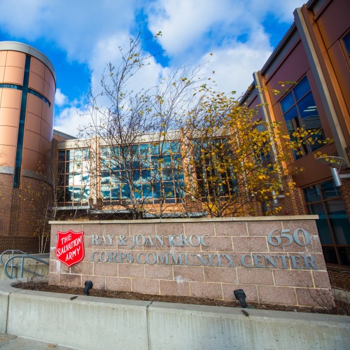A modern building with copper colored walls and wide windows in front of a blue sky