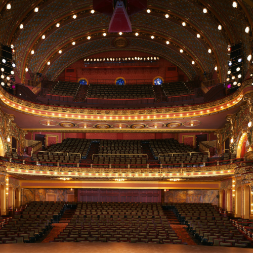 A view from the stage into the three tiered auditorium with ornate box seats cascading 
