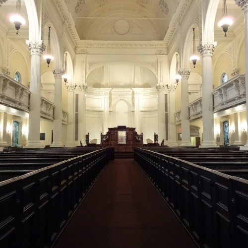 A large sanctuary with ornate pillars and dark wooden pews
