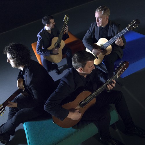 dublin guitar quartet, sitting in a diamond but facing away from each other. they are photographed from an askew angle. they are lit from the side and cast strange shadows