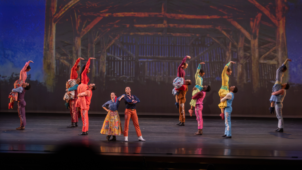 dancers in front of a backdrop of a barn