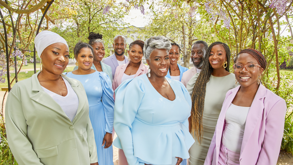 members of the kingdom choir in pastel outfits under flowering spring branches