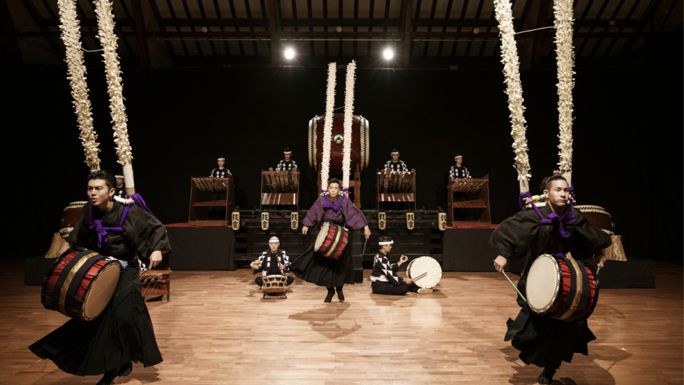 members of the kodo ensemble perform on hand held drums