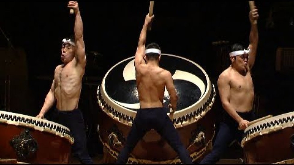 Three men play an excerpt of KODŌ's "O-Daiko" on taiko drums.