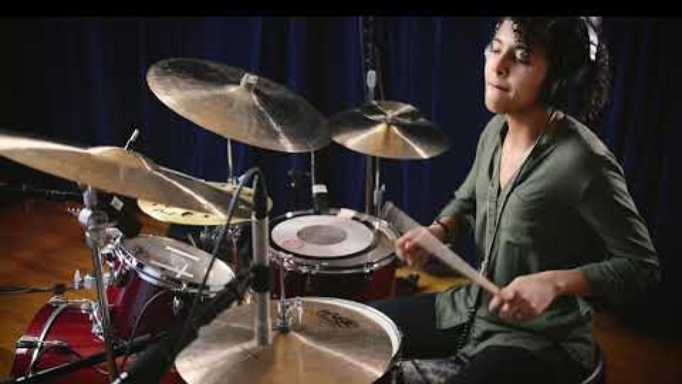 drummer ivanna cuesta performs with her band in a music studio