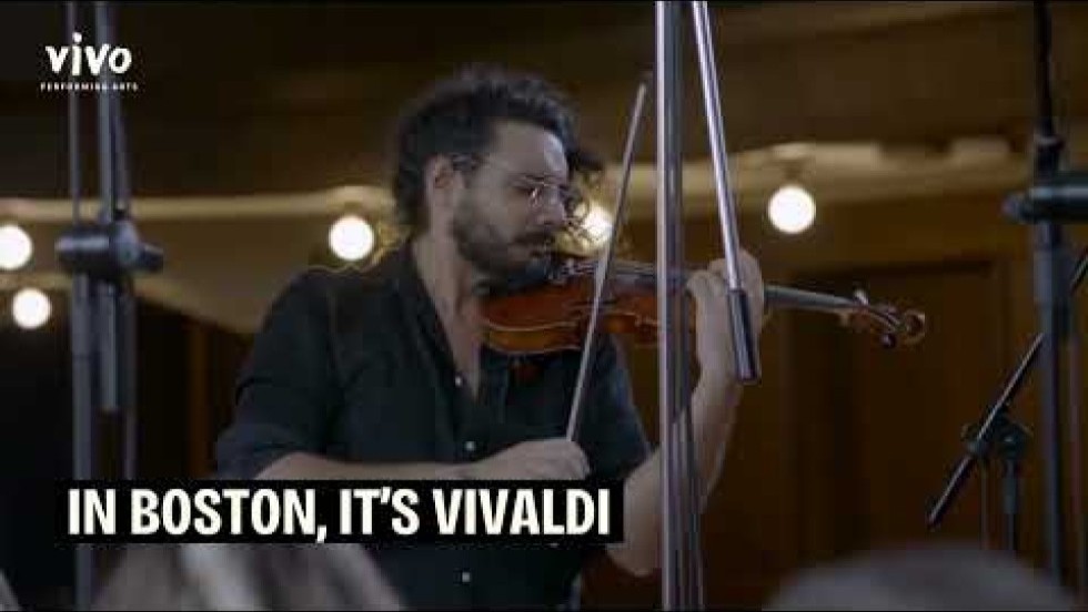 a chamber orchestra rehearses onstage in a concert hall