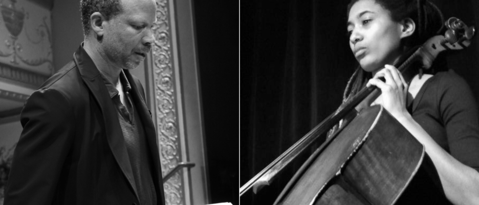 Craig Taborn, a man with light hair stands in front of a patterned wall in a blue shirt smiling. 