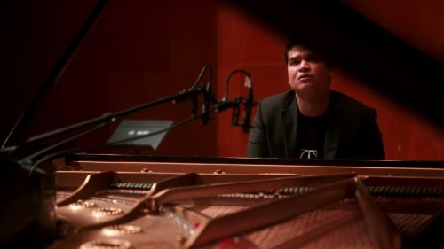 pianist ahmed alom, through the open lid of a piano