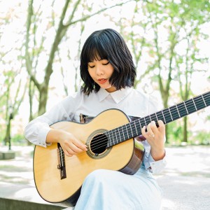 a young asian-american woman plays the guitar