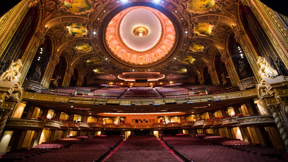 A view from the stage, out into a large auditorium with ornate gold decorations and paintings