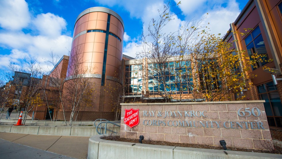 A modern building with copper colored walls and wide windows in front of a blue sky