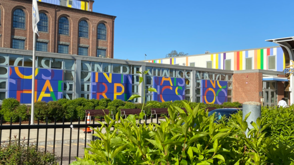 metal and painted letters spell out  Renaissance Charter School on a building that blends contemporary and historical elements