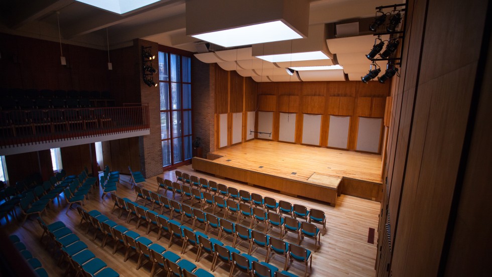 a small auditorium space filled with blue chairs