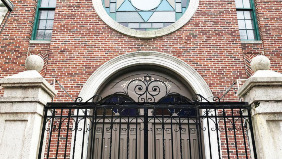 a stained glass window with a star of david above an arced doorway